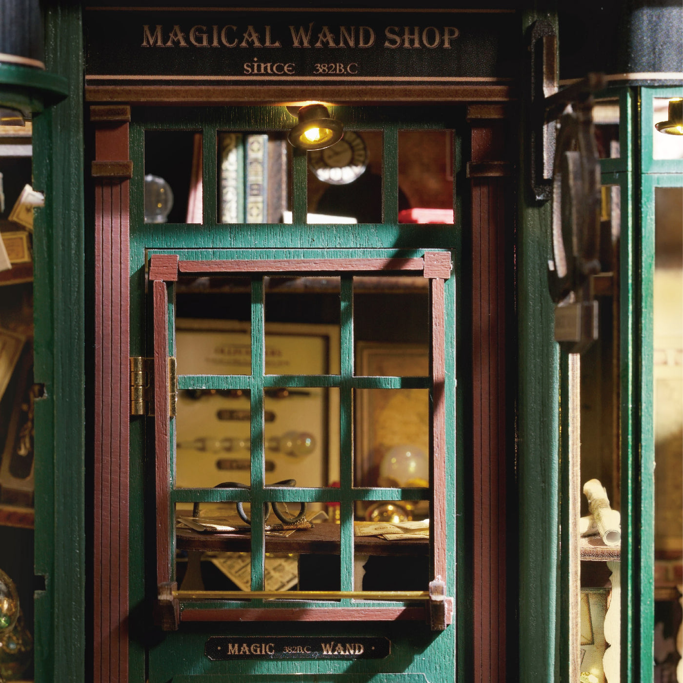 Modèle miniature détaillé d’un magasin de baguettes magiques vert foncé avec une vitrine.