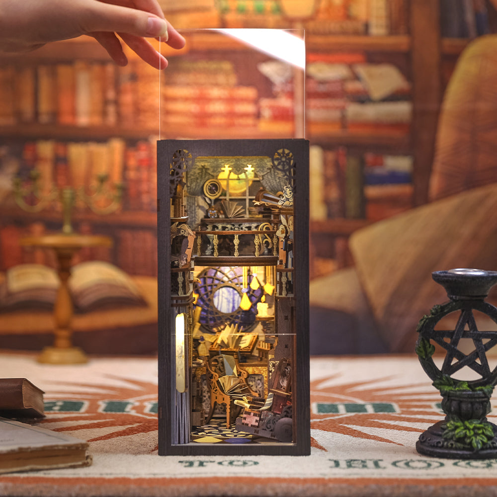 Un diorama miniature illuminé et très détaillé d’une bibliothèque à plusieurs étages ou d’un cabinet de travail de sorcier, conçu pour tenir sur une étagère.
