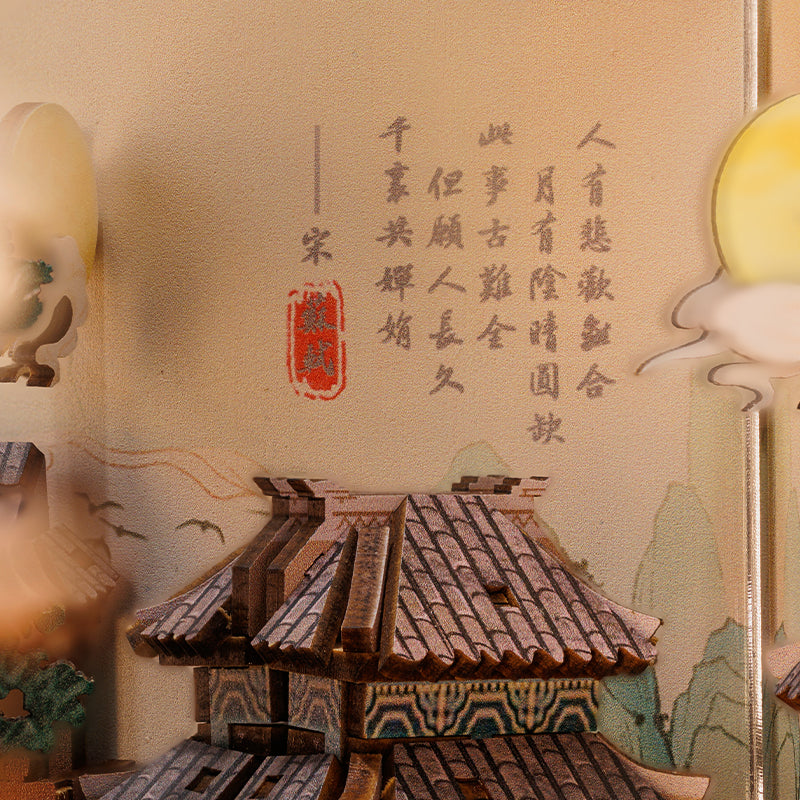 Œuvre d’art décorative chinoise représentant la calligraphie, la pleine lune et l’architecture traditionnelle.