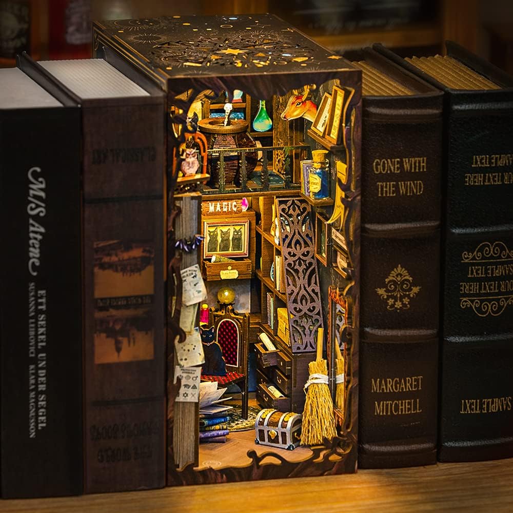 Un diorama miniature détaillé d’un cabinet de travail magique, conçu pour être placé entre des livres sur une étagère.