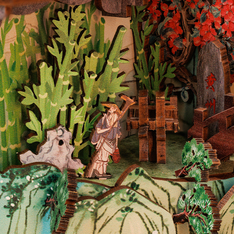 Diorama détaillé représentant un paysage asiatique traditionnel avec un personnage, des bambous, des arbres et des montagnes.