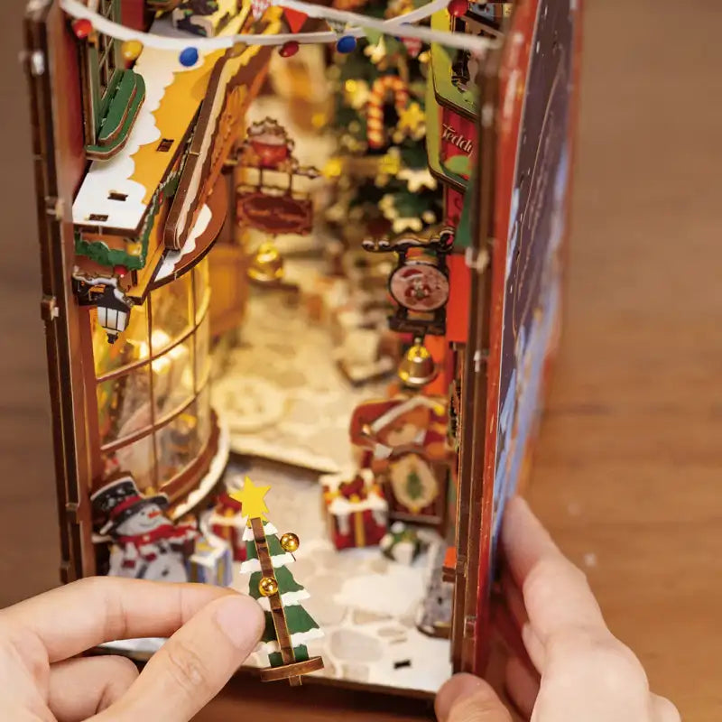 Une scène de rue de Noël miniature fabriquée à la main avec des détails complexes et un éclairage chaleureux.