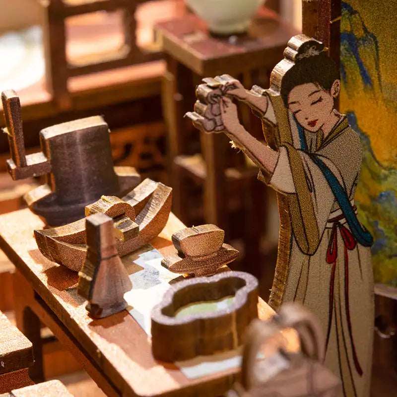 Scène de maison de poupée miniature en bois avec une femme préparant du thé