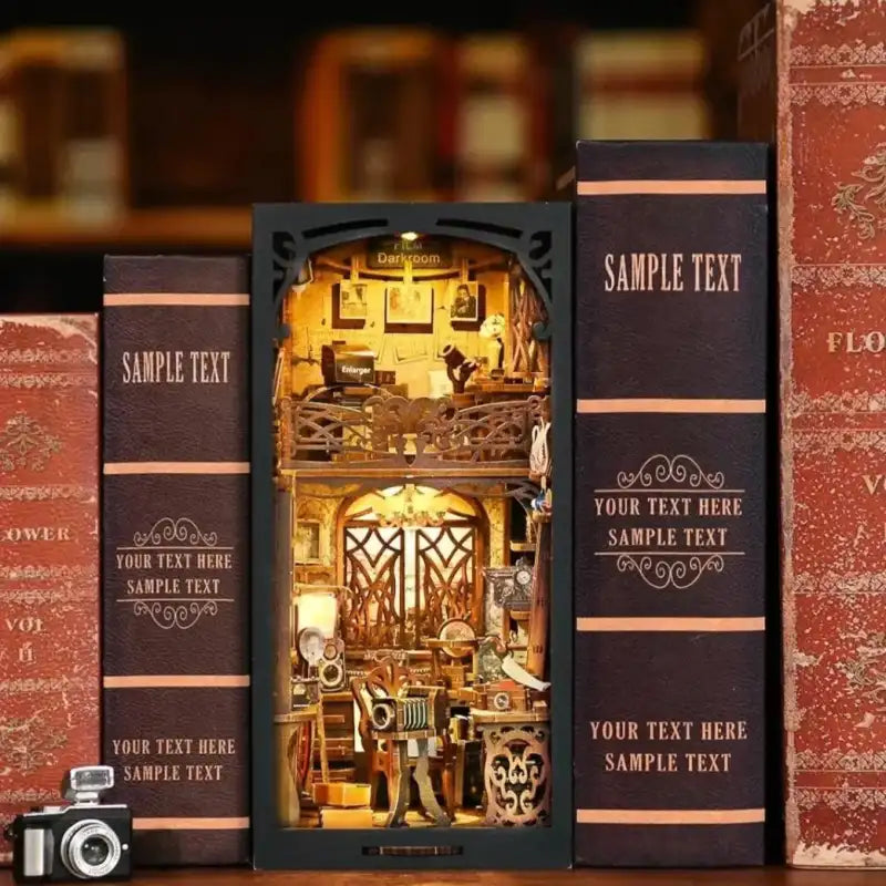 Diorama miniature éclairé, à deux étages, dans un cadre en forme de livre, représentant un intérieur orné.