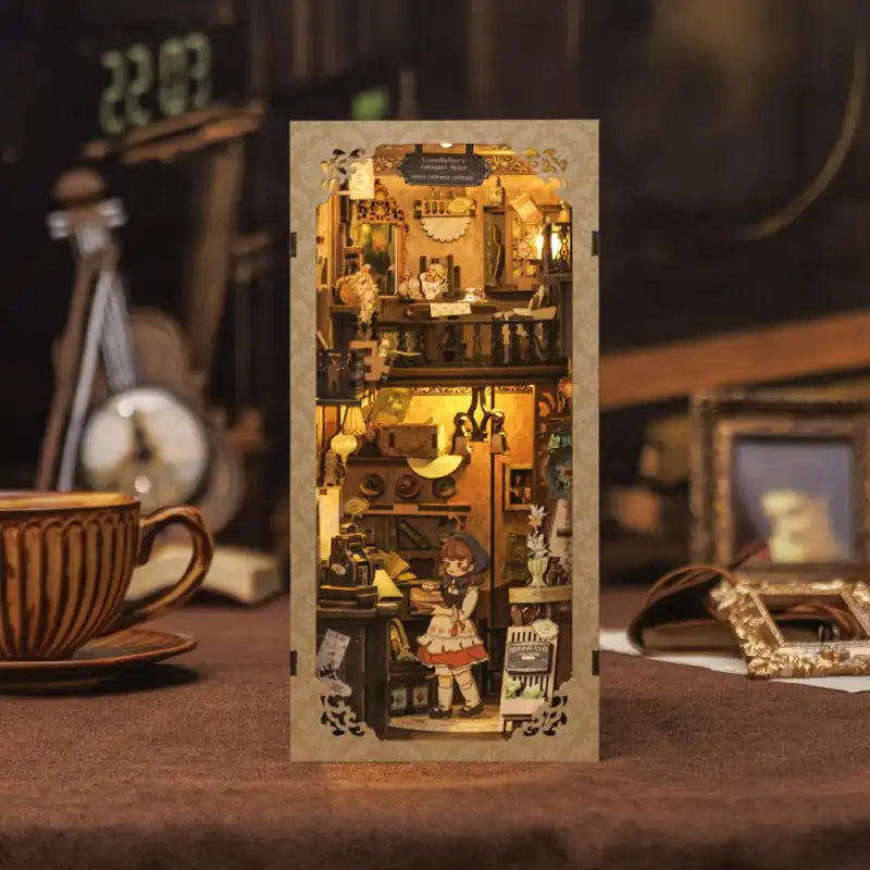 Un diorama miniature éclairé de deux étages, comprenant un intérieur détaillé avec des meubles et un personnage, conçu pour tenir sur une étagère.