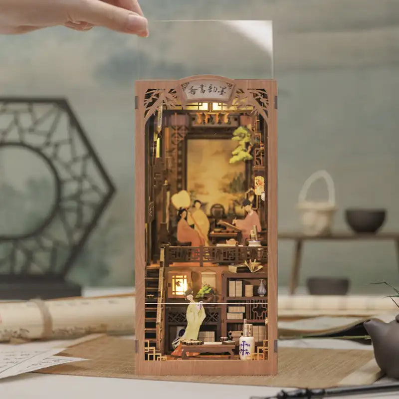 Diorama miniature en bois d’un ancien cabinet de travail chinois, avec des détails complexes et un éclairage intérieur.