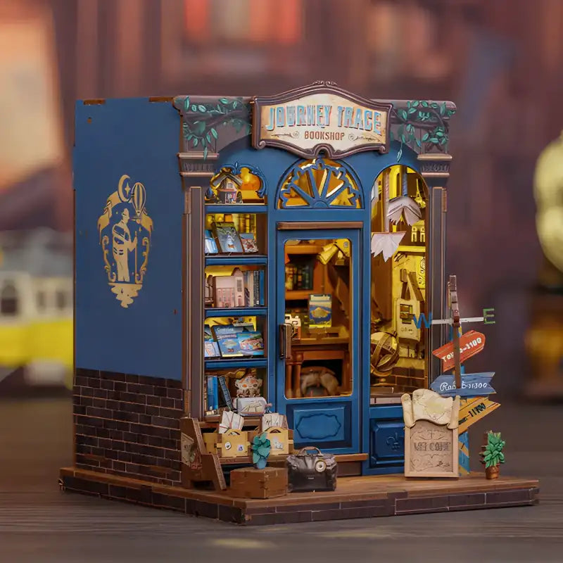 Un diorama miniature très détaillé d’une librairie ’Journey Trace’ avec des intérieurs éclairés.