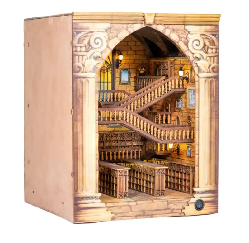 Diorama miniature détaillé d’une bibliothèque à plusieurs niveaux avec des escaliers en colimaçon.