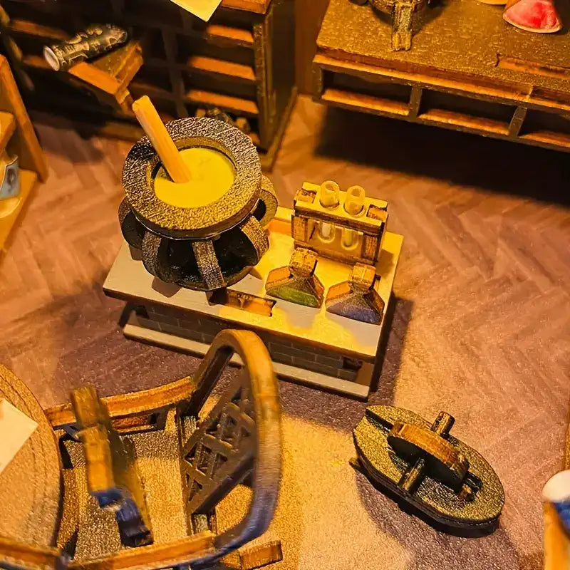 Un poste de travail d’alchimiste miniature avec un chaudron, un support pour tubes à essai et des flacons.