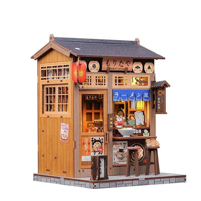 Modèle miniature en bois d’un magasin de ramen japonais, avec des détails et des éclairages complexes.