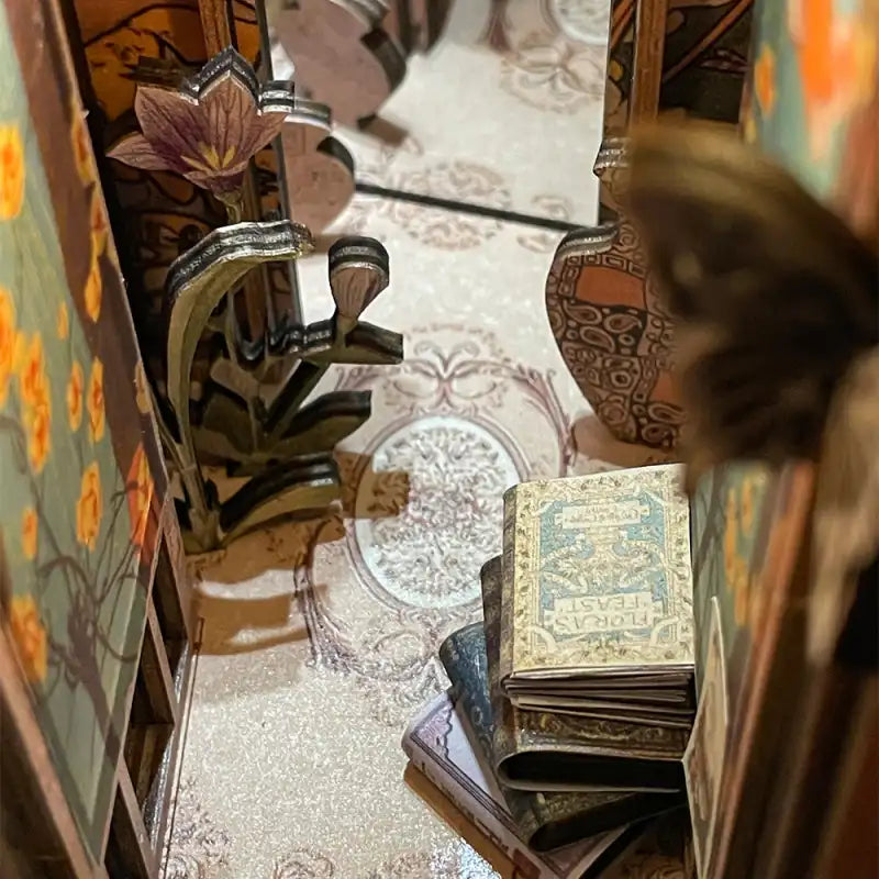 Un livre miniature avec une couverture à motifs bleu clair et or.