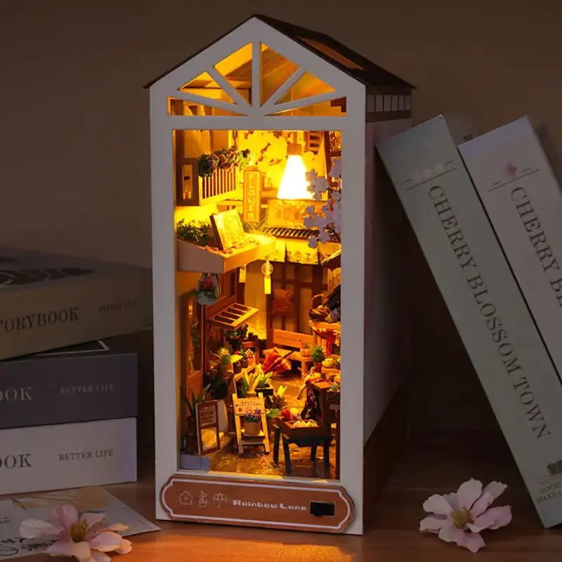 Maison de poupée miniature illuminée ou diorama en forme de bâtiment avec une scène intérieure détaillée.