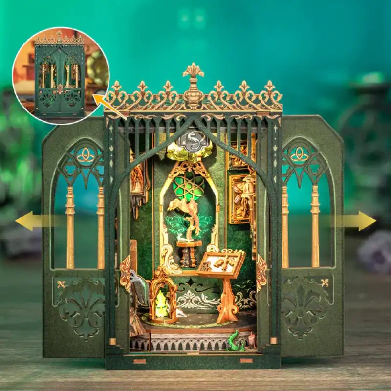 Bibliothèque ou vitrine miniature de style gothique, vert foncé, aux détails complexes, avec des portes ouvrables. L’intérieur est doré et orné de petits éléments décoratifs tels qu’une statue, des livres et une lanterne.