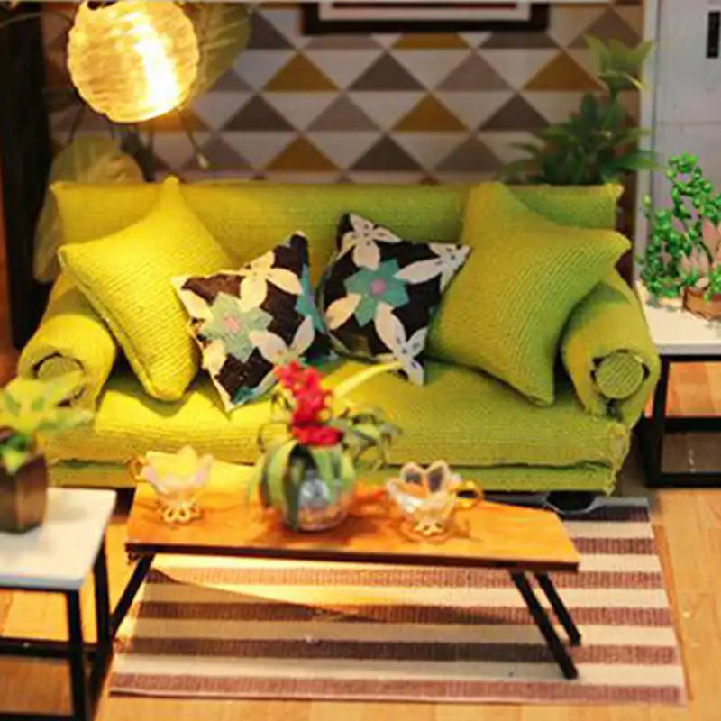 Un canapé vert miniature avec des coussins décoratifs.