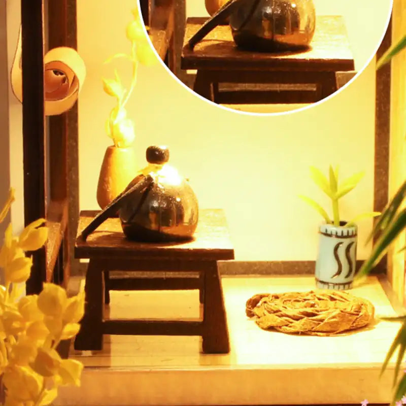 Un service à thé miniature avec une théière foncée sur une petite table en bois.