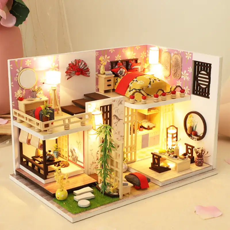 Une maison de poupée miniature illuminée, à plusieurs niveaux, avec un décor d’inspiration asiatique.