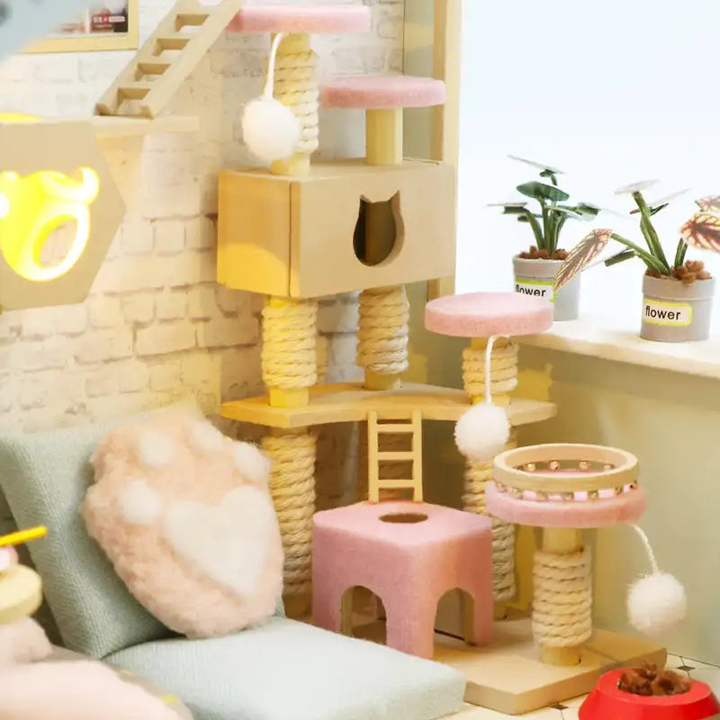 Un arbre à chat à plusieurs niveaux avec des griffoirs, des plates-formes, une maison pour chats et des jouets suspendus.