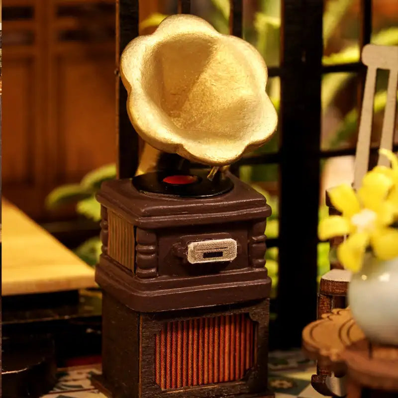 Gramophone miniature de couleur marron avec un pavillon doré.