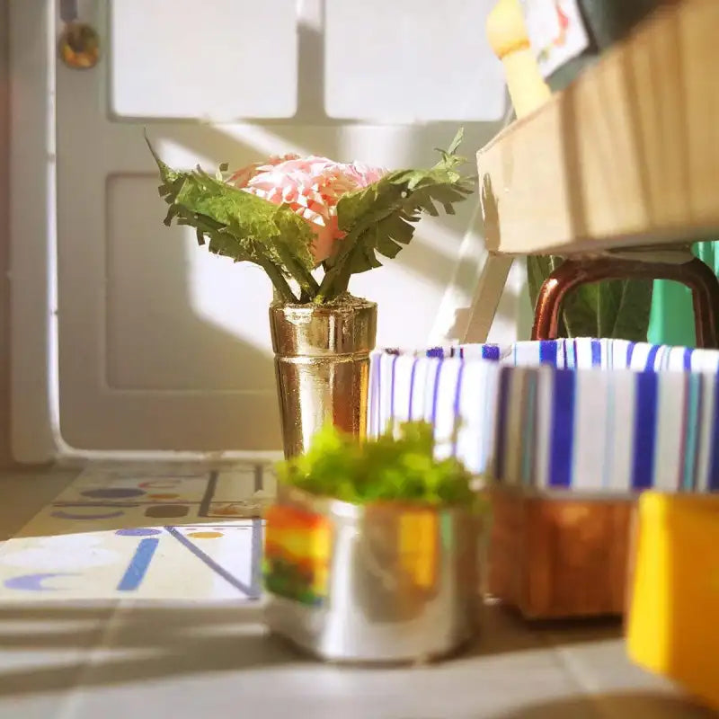 Arrangement de fleurs roses dans un vase doré.