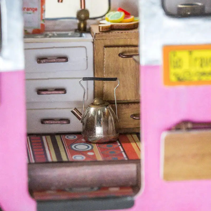 Bouilloire en métal argenté avec une poignée noire.