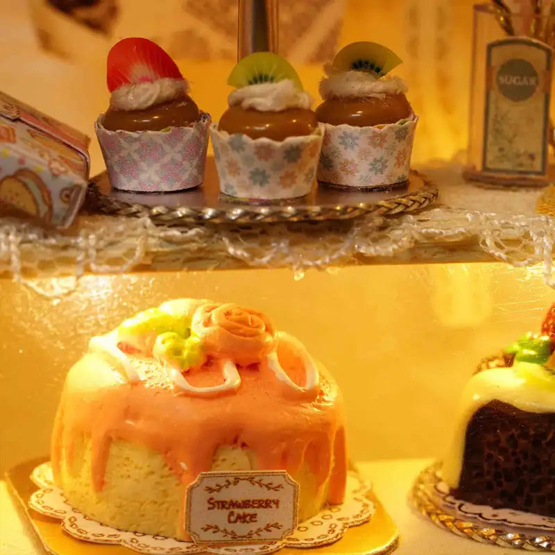 Une sélection de gâteaux miniatures et de cupcakes présentés dans une vitrine de boulangerie.