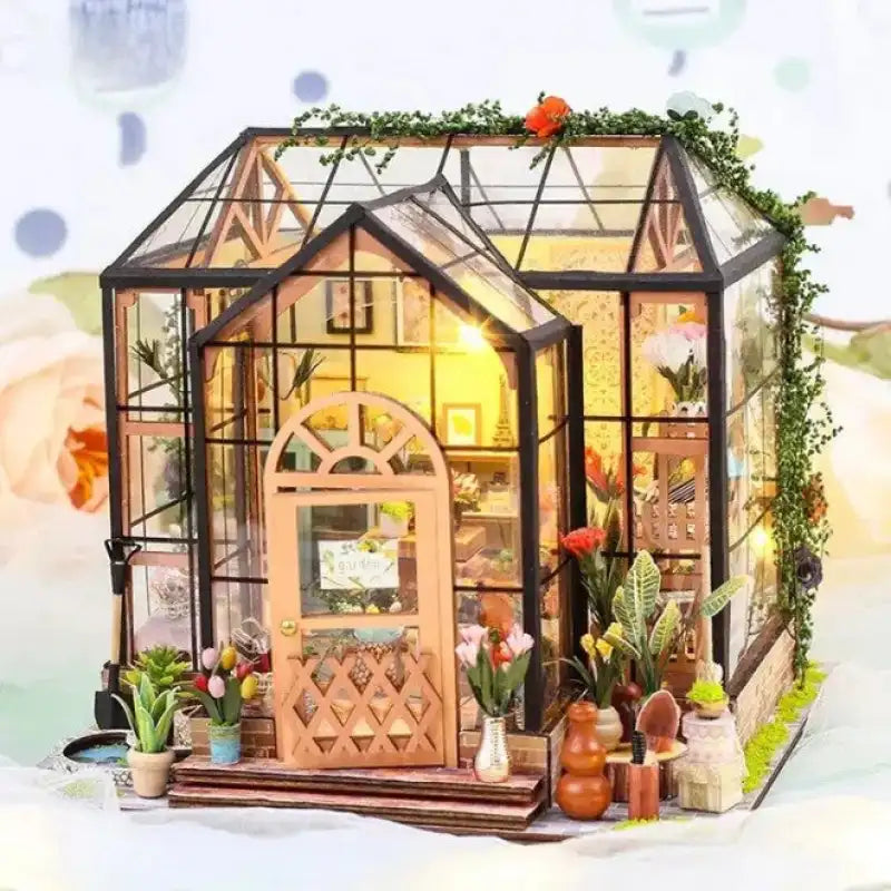 Maison de poupée illuminée avec serre miniature, détails et plantes complexes.