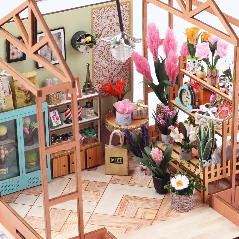 Un magasin de fleurs miniature pour maison de poupée avec diverses plantes et décorations.