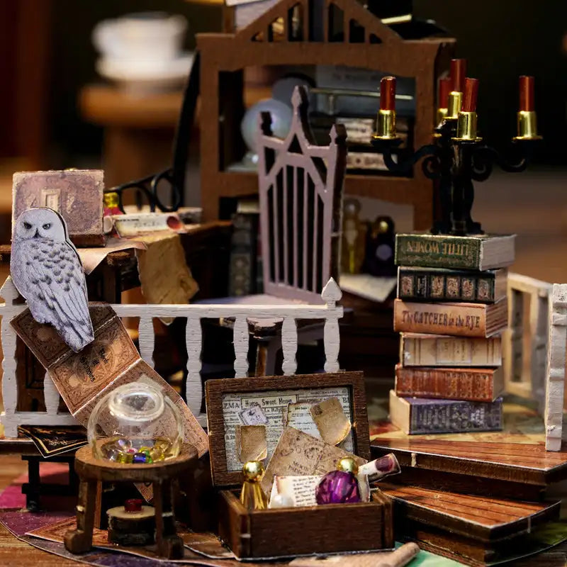 Diorama miniature à plusieurs niveaux d’un cabinet de travail ou d’une bibliothèque magique, avec un hibou, de petits livres, un chandelier et divers flacons de potion.