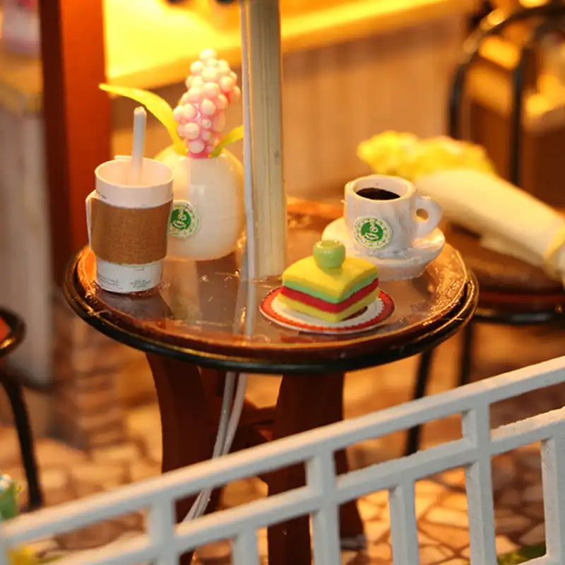 Table de café miniature avec boissons et gâteaux.