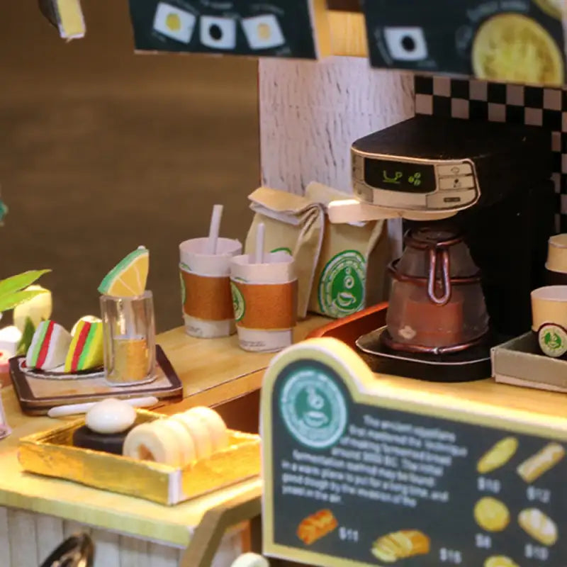 Présentoir de café miniature avec boissons, pâtisseries et cafetière.