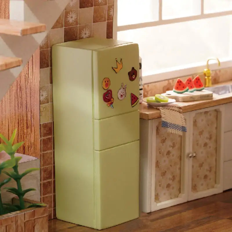 Réfrigérateur vert clair à deux portes avec aimants colorés