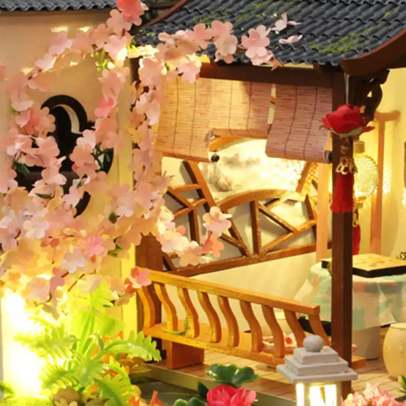 Maison asiatique traditionnelle miniature avec des cerisiers en fleurs.