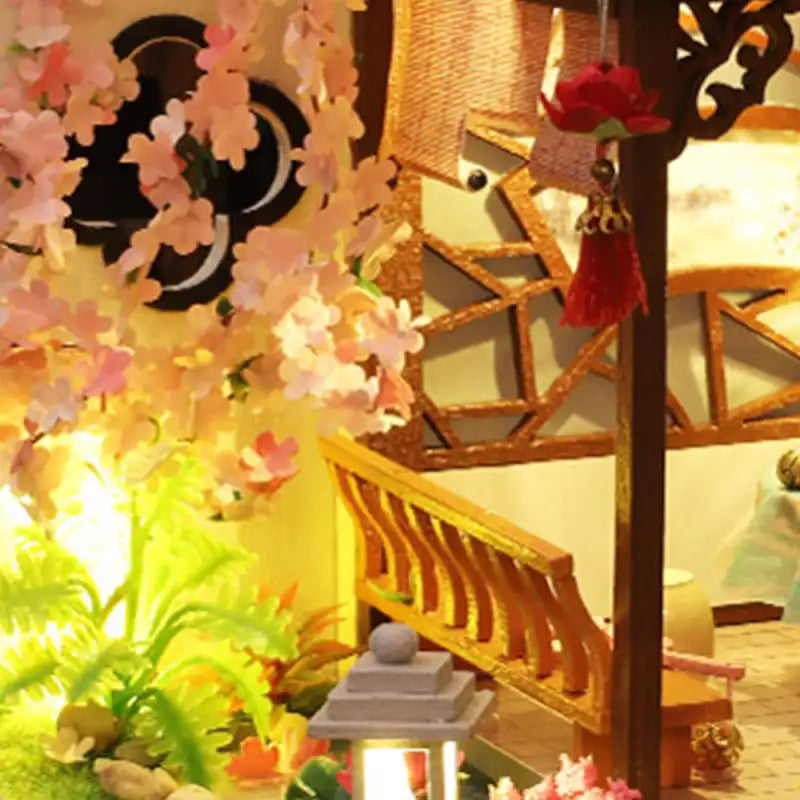 Intérieur de maison de poupée miniature de style japonais avec des cerisiers en fleurs et un escalier.