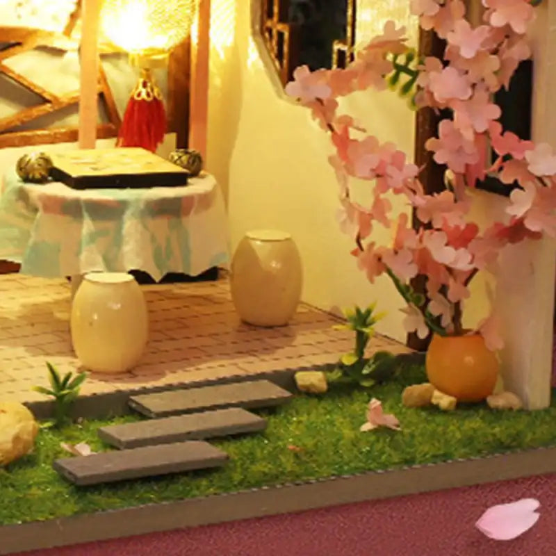 Une chambre de maison de poupée miniature avec un jardin et un intérieur détaillés.