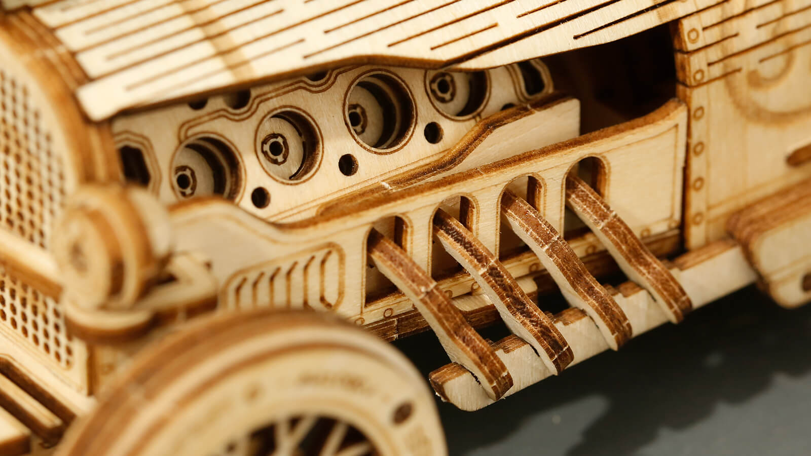Modèle réduit de voiture en bois avec détails visibles du moteur.