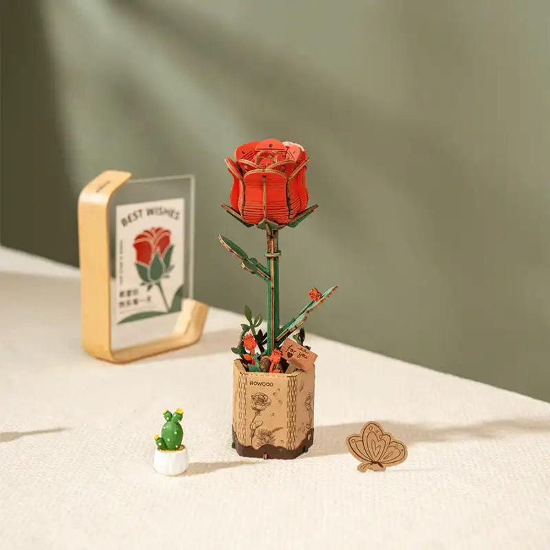 Un modèle de rose en bois, rouge et en pot.