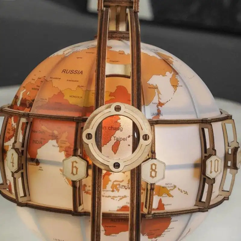 Un globe terrestre mécanique en bois avec un système d’engrenage complexe.