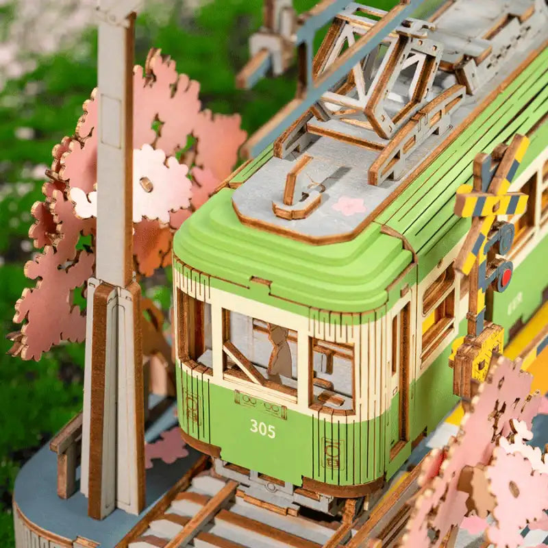 Modèle en bois détaillé d’un tramway vert avec pantographe.