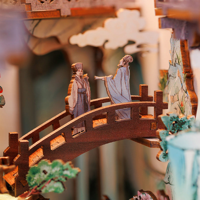 Diorama en bois détaillé, découpé au laser, représentant deux personnages sur un pont dans un paysage chinois traditionnel.