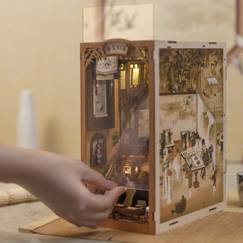 Un diorama de bibliothèque en bois, illuminé et complexe, avec une scène de rue traditionnelle de l’Asie de l’Est.