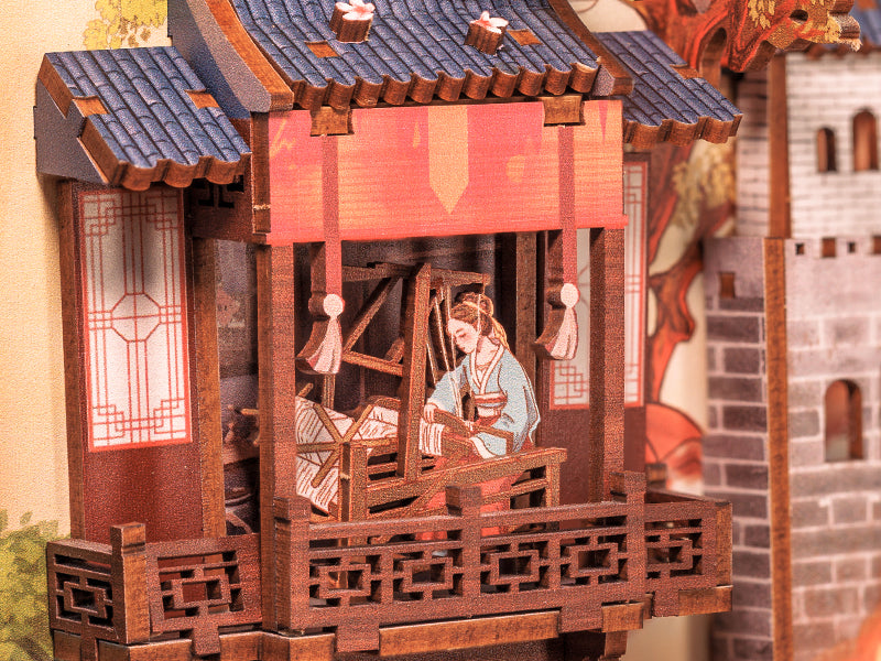 Modèle miniature détaillé en bois d’un bâtiment traditionnel d’Asie de l’Est avec une femme en train de tisser à l’intérieur.