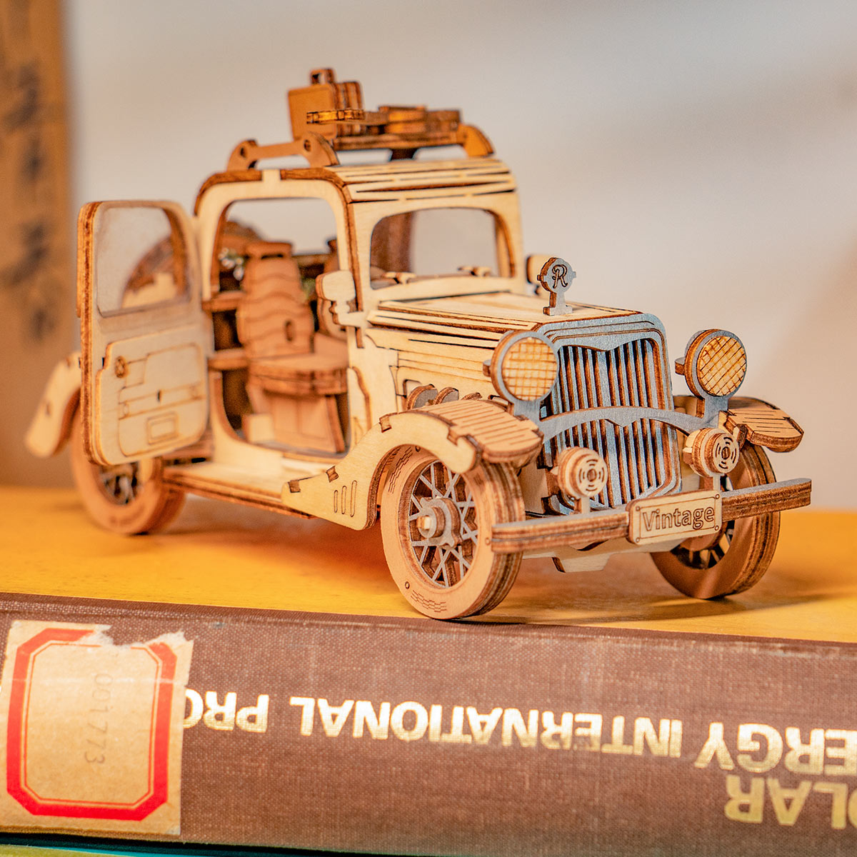 Une maquette de voiture en bois finement travaillée avec des détails complexes et une porte ouverte.
