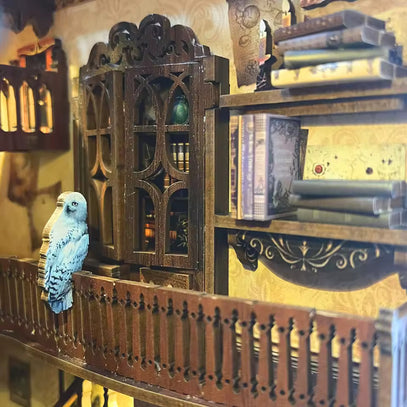 Chambre de maison de poupée miniature avec une armoire de style gothique, une bibliothèque et une figurine de hibou blanc sur un balcon.
