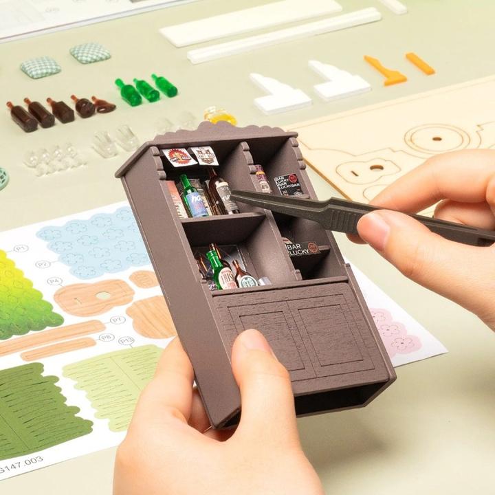 Meuble de bar miniature pour maison de poupée avec de petites bouteilles et des accessoires.