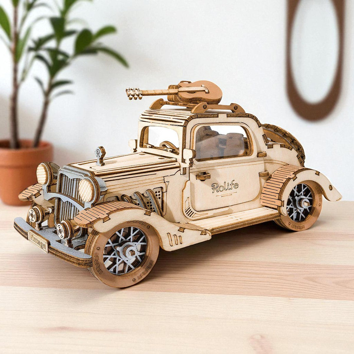 Modèle en bois d’une voiture de collection avec une guitare sur le toit.