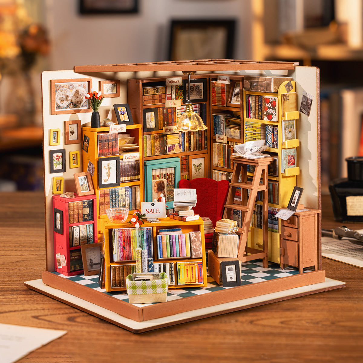 Un diorama de librairie miniature, très détaillé, avec des étagères de petits livres, un bureau, une chaise et une échelle.
