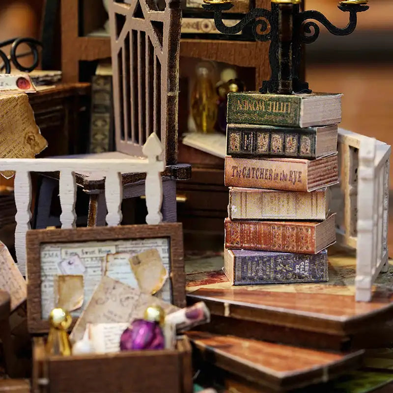 Chambre de maison de poupée miniature avec un livre ouvert, de petits meubles et de minuscules objets décoratifs.